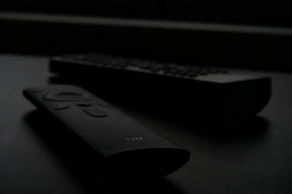 A Mi TV Box device and a remote in a dark room